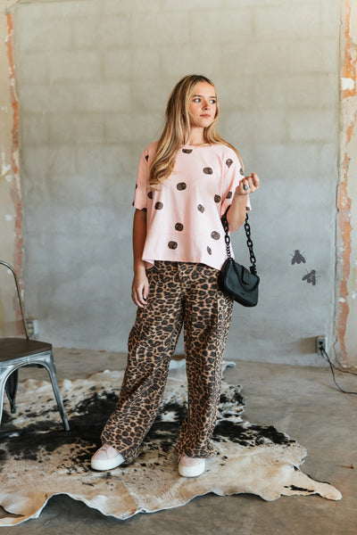 Leopard print wide leg jeans styled with pink top and sneakers
